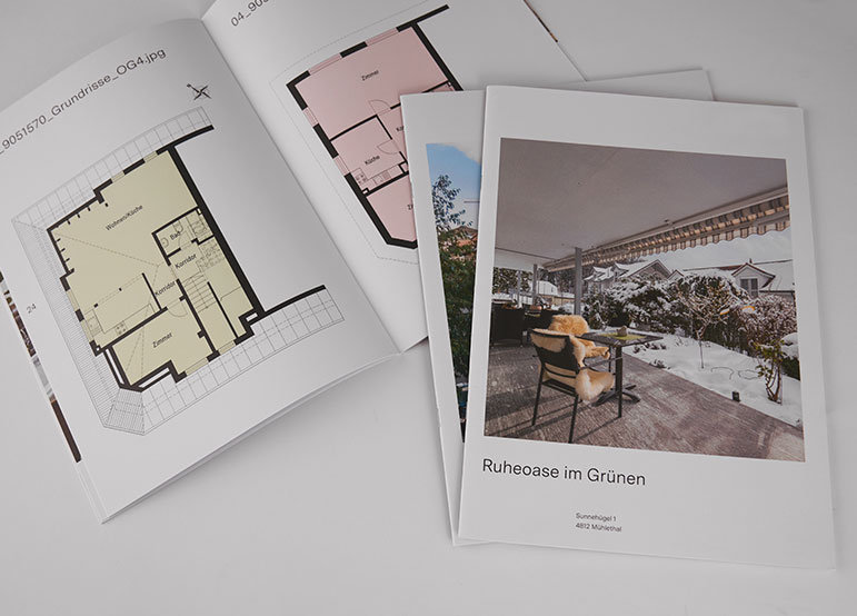 Architectural brochure and floor plans Several brochures with softcover binding are spread out, showing architectural floor plans and an outdoor terrace with seating. One brochure cover features a photograph of a snowy garden patio with a chair, table and plants.