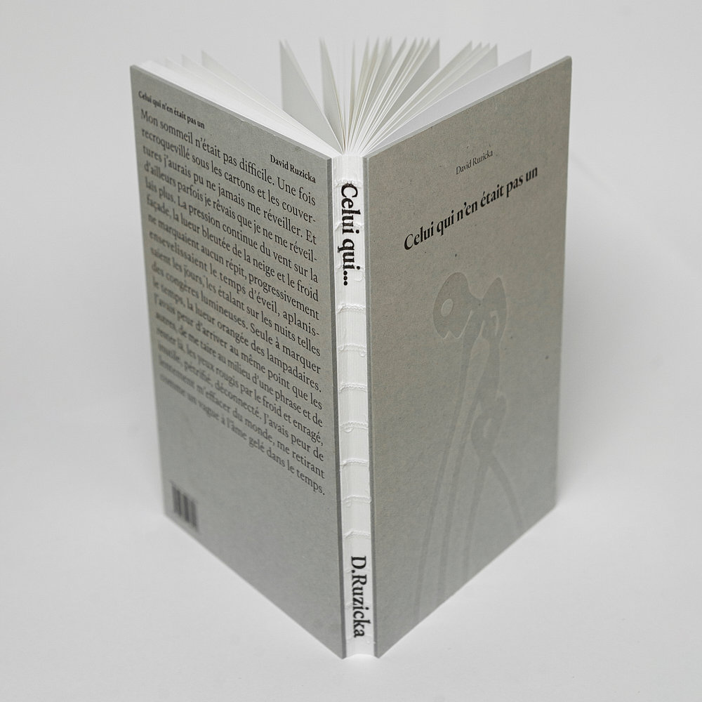 Offener Buchrücken mit Fadenheftung und grauem Umschlag Celui qui n'en était pas un
