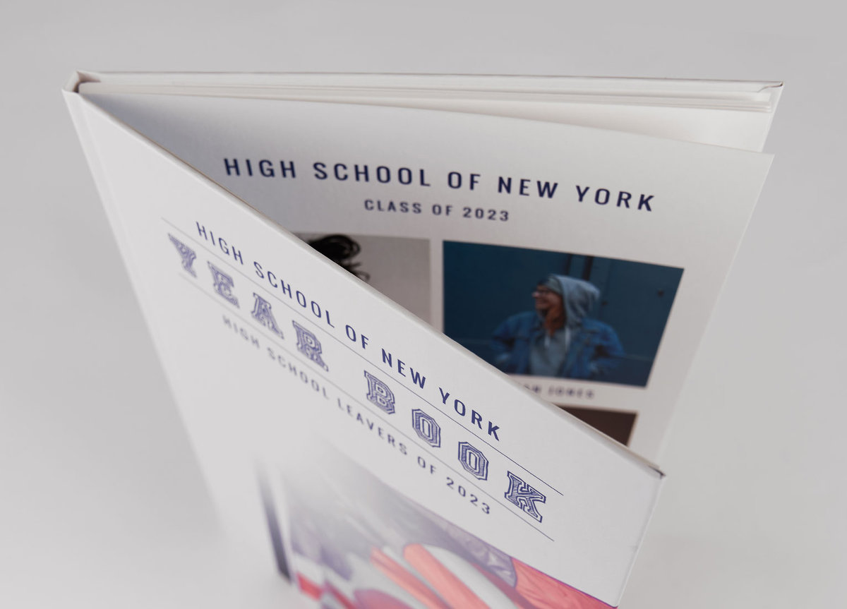 Brochure couverture rigide ouverte Brochure reliée en dos cousu, avec une couverture souple blanche imprimée pour le classement 2023 du lycée de New York, montrant des images et du texte en bleu foncé.